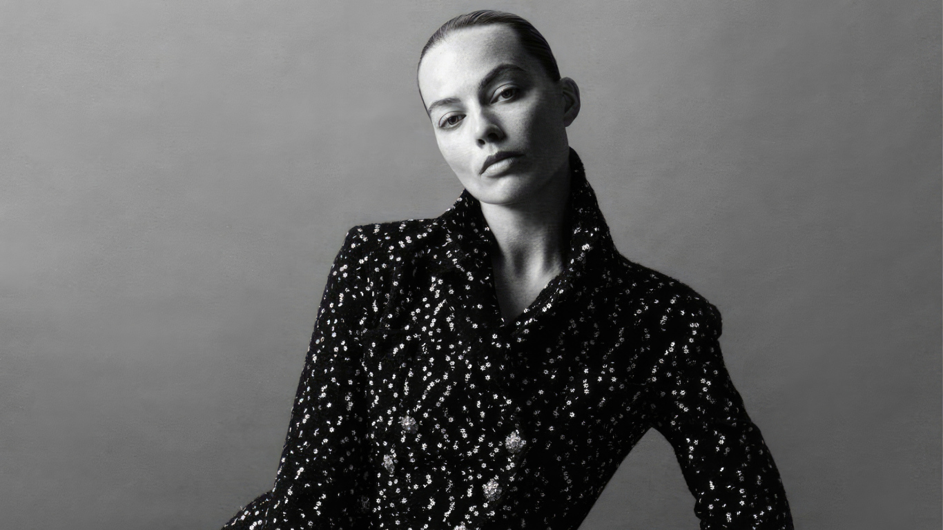 Грустная Марго Робби в блестящем пиджаке на сером фоне