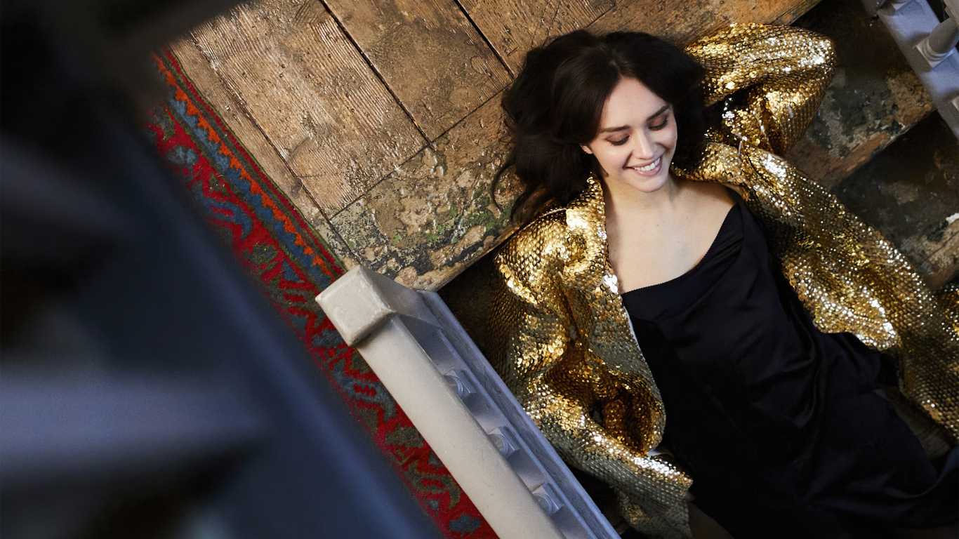 Улыбающаяся актриса Оливия Кук в черном платье