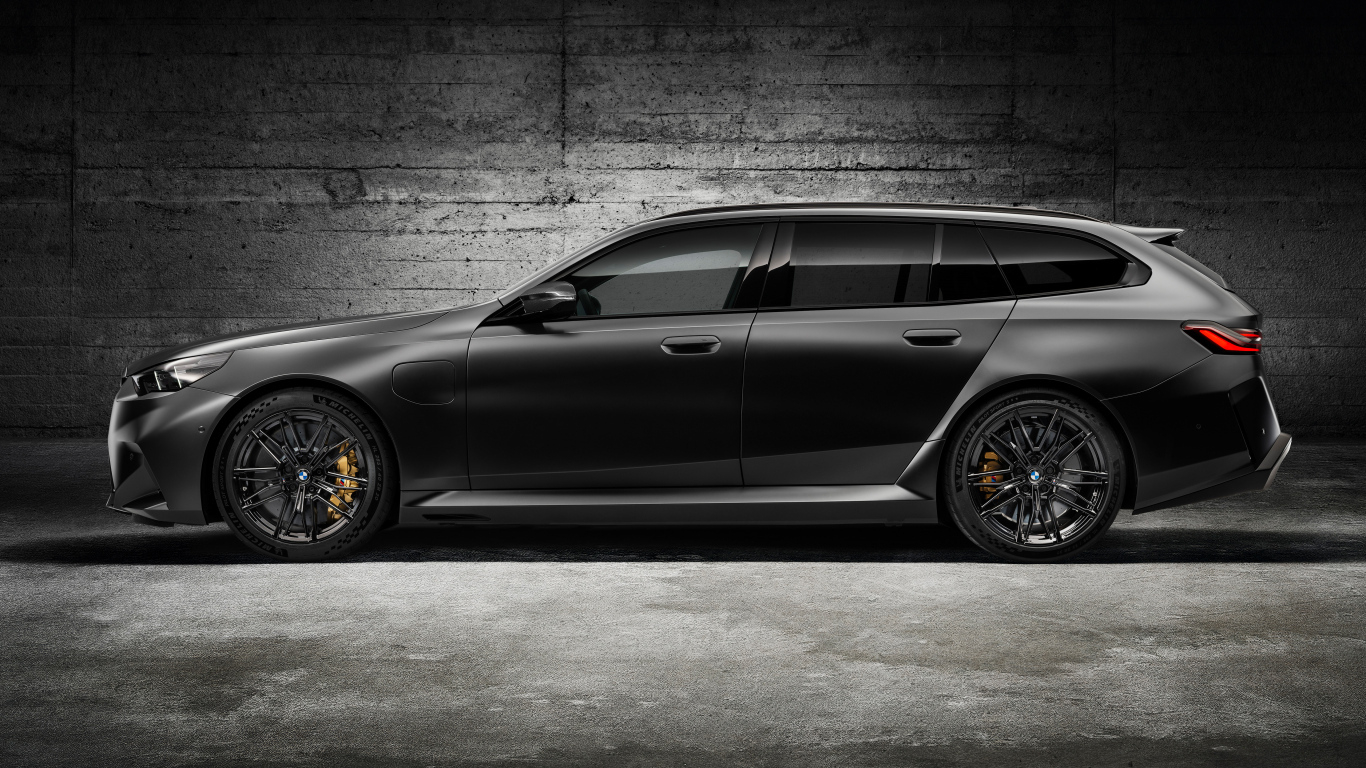 Вид сбоку на черный автомобиль BMW M5 Touring 2024 года
