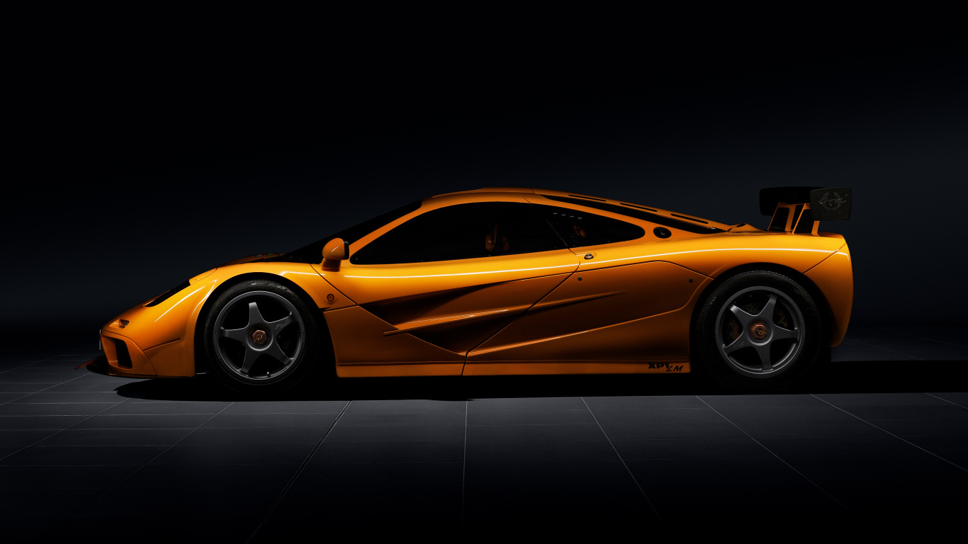 Вид сбоку на оранжевый автомобиль  McLaren F1 LM