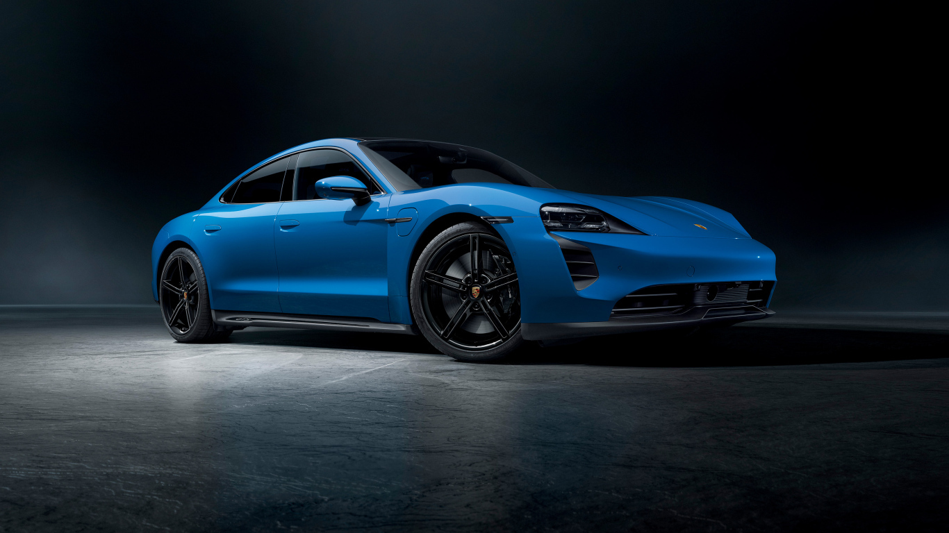 Синий автомобиль Porsche Taycan GTS на черном фоне