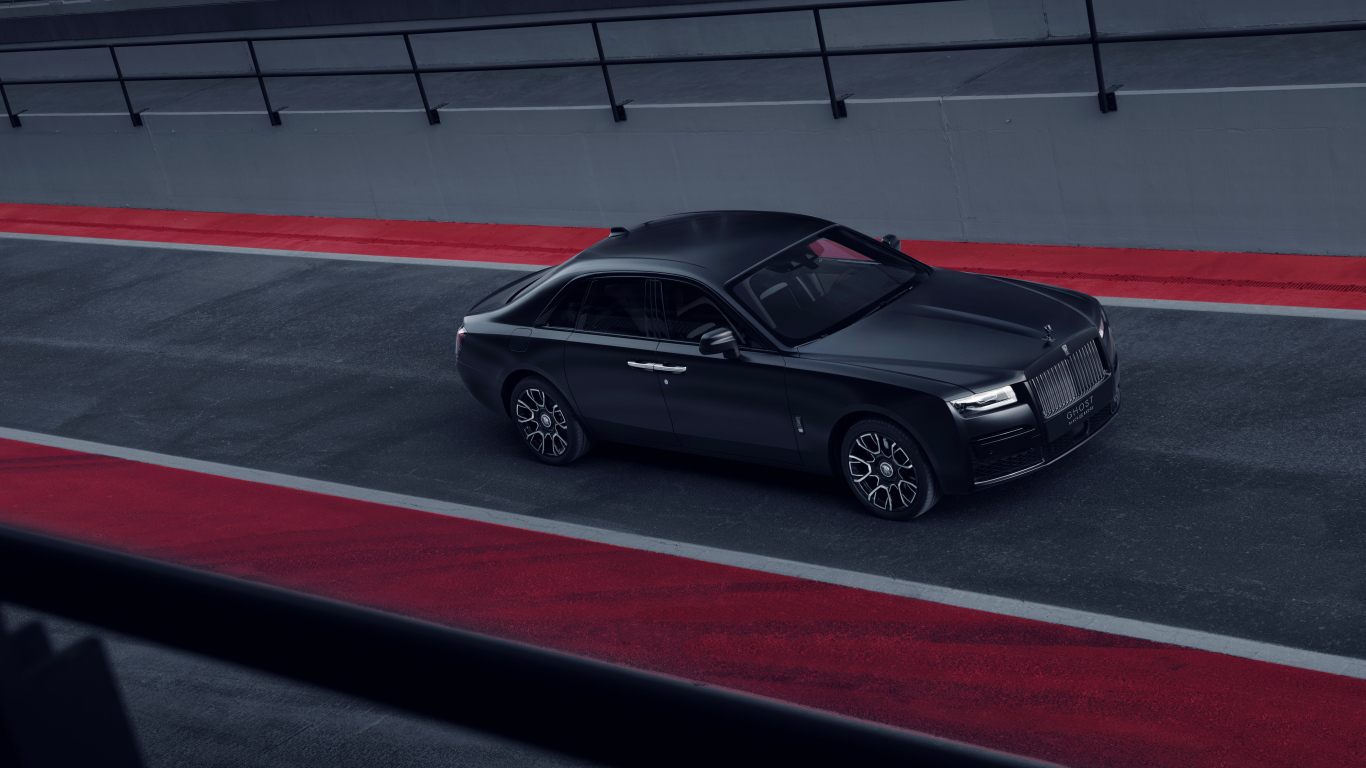 Черный автомобиль Rolls-Royce Black Badge Ghost на дороге