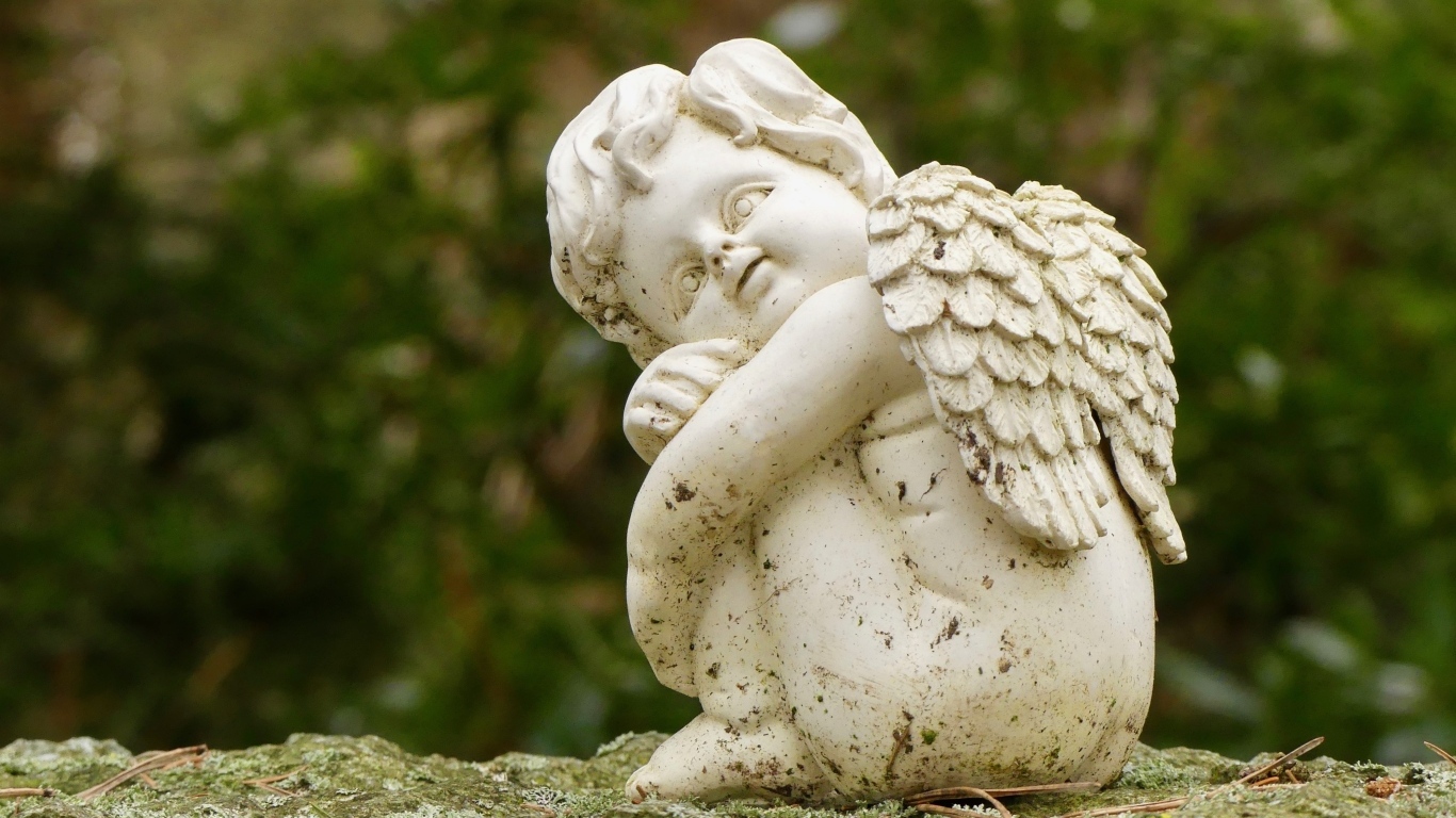 Статуэтка ангела стоит на камне