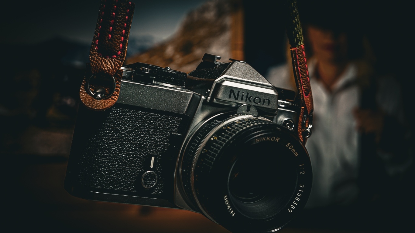 Черный фотоаппарат nikon на ремне