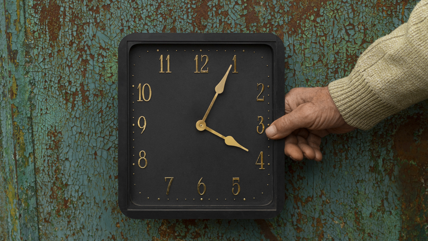 Черные квадратные часы на старой стене