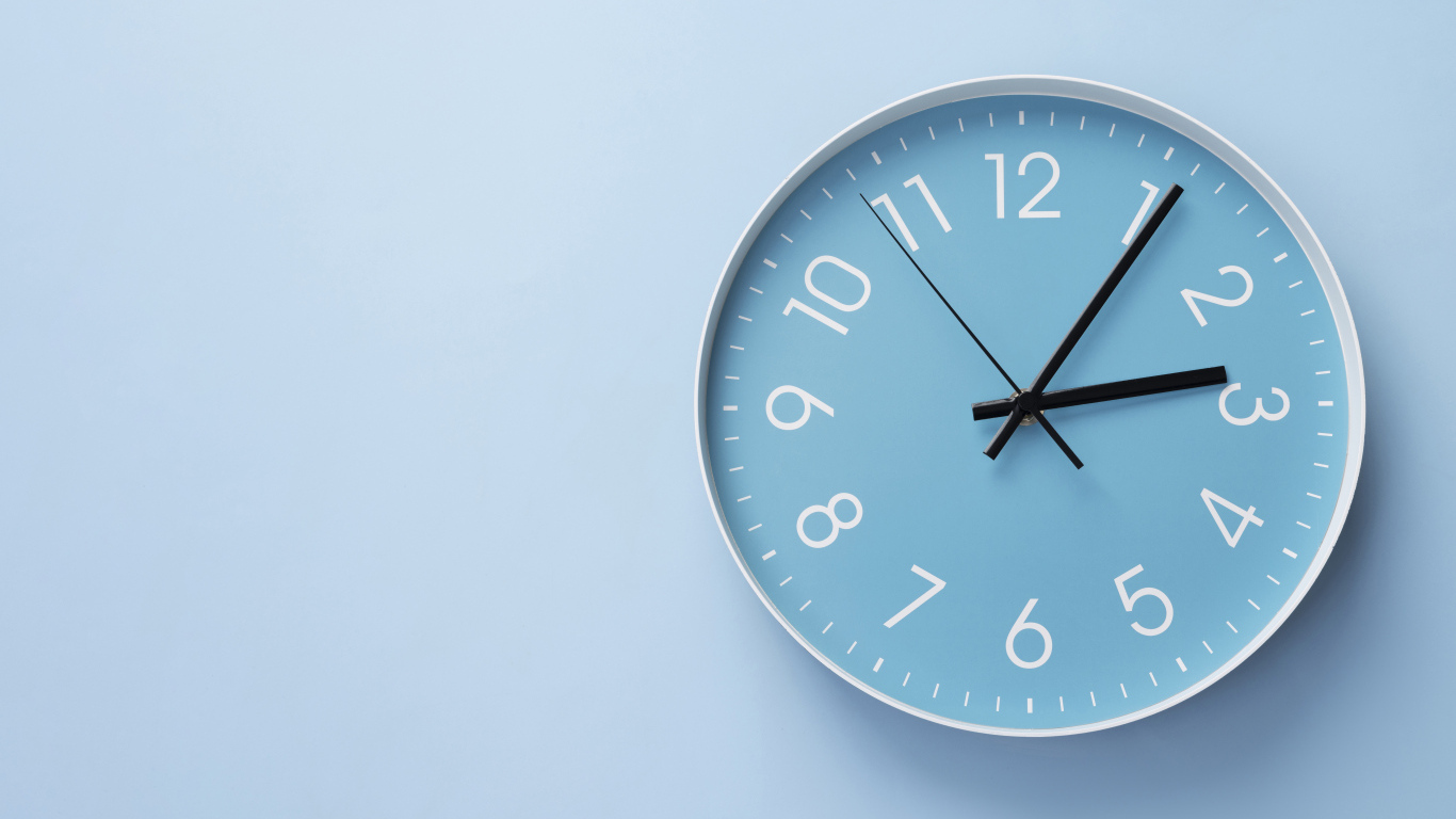 Круглые часы на голубом фоне крупным планом
