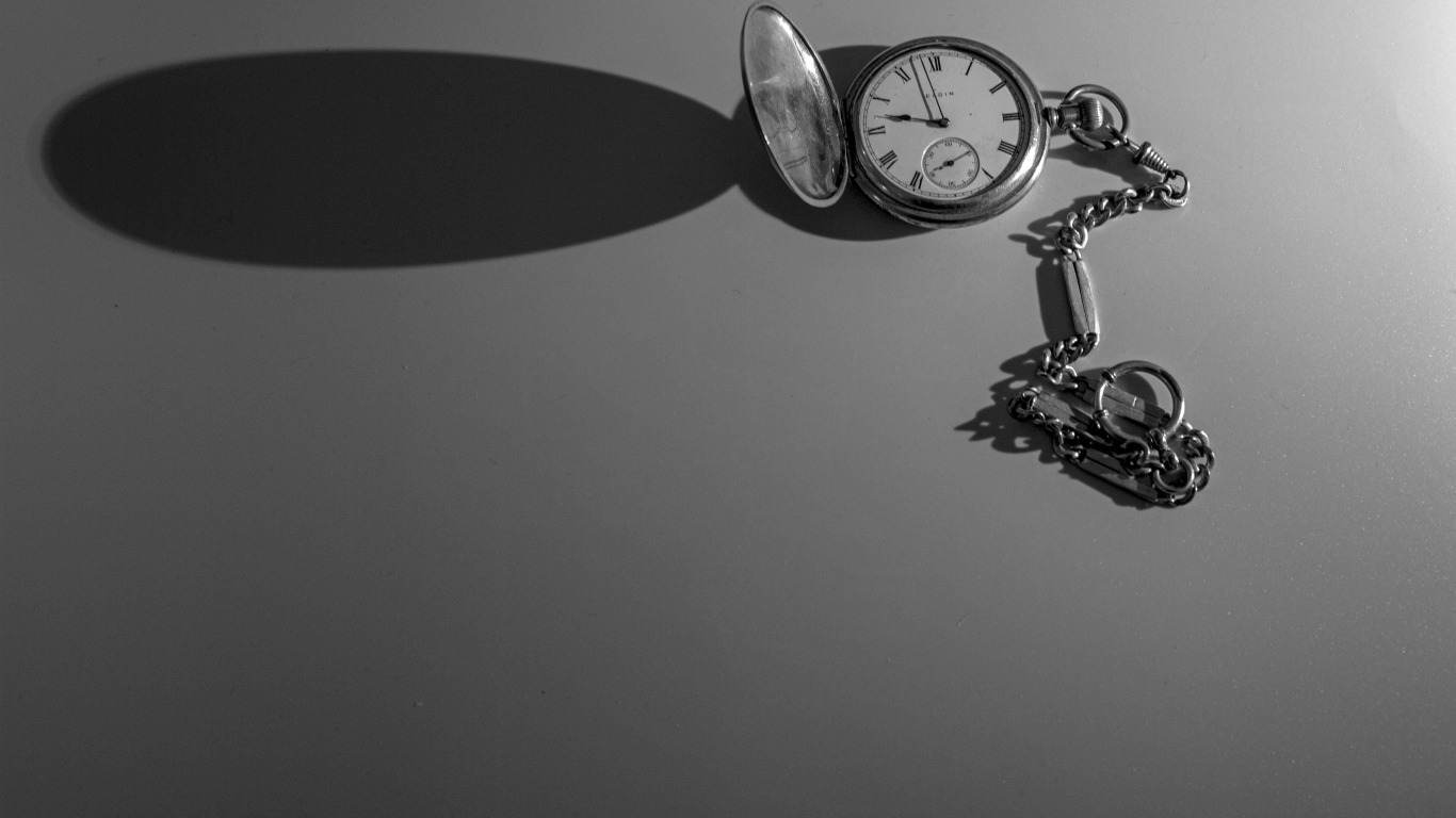 Тень от карманных часов на сером фоне
