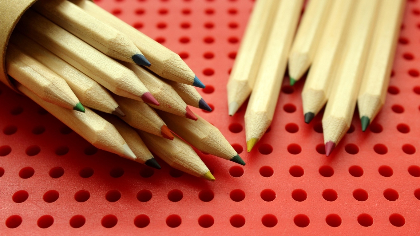 Заточенные карандаши на красном фоне