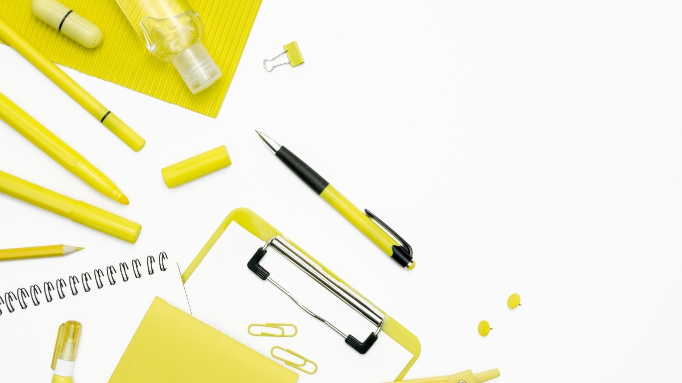 Желтые канцелярские предметы на белом фоне