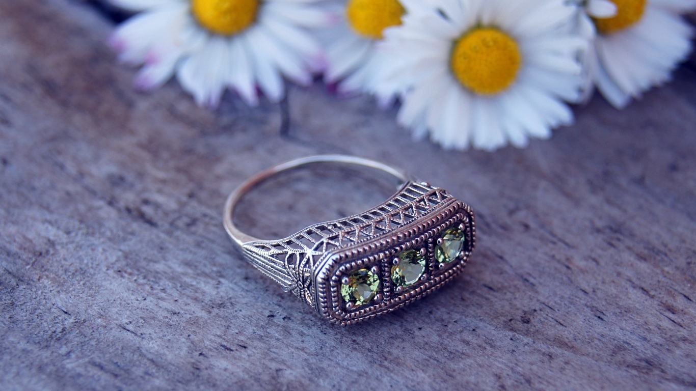 Старинный перстень на столе с ромашками