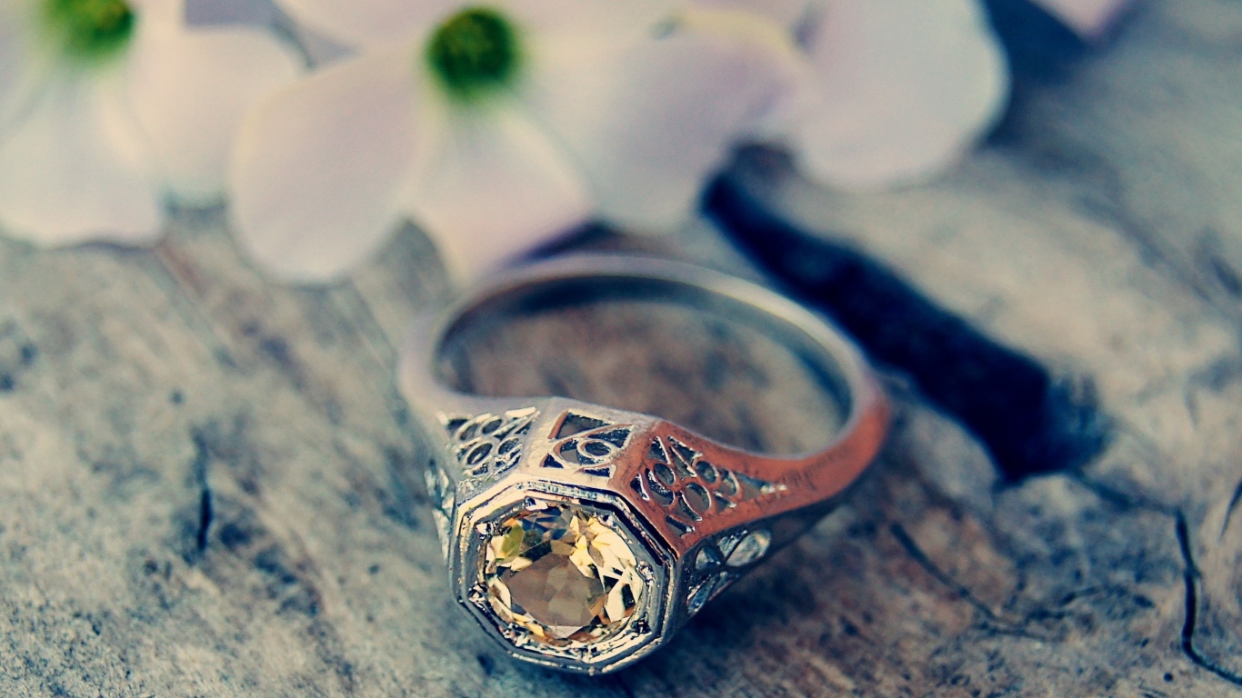 Перстень с камнем на деревянном столе 