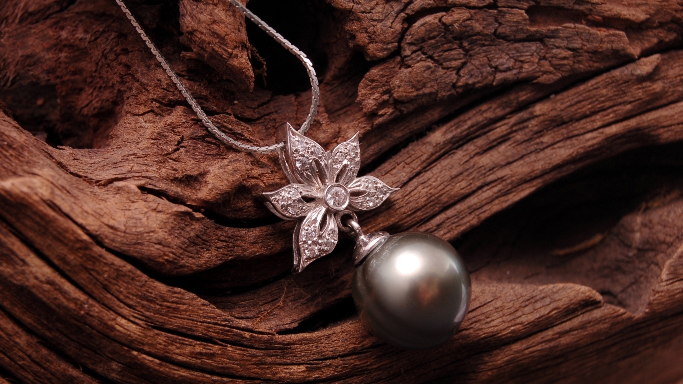 Кулон на цепочке лежит на старом дереве