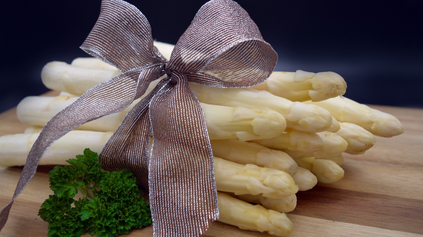 Спаржа с бантом на столе с петрушкой