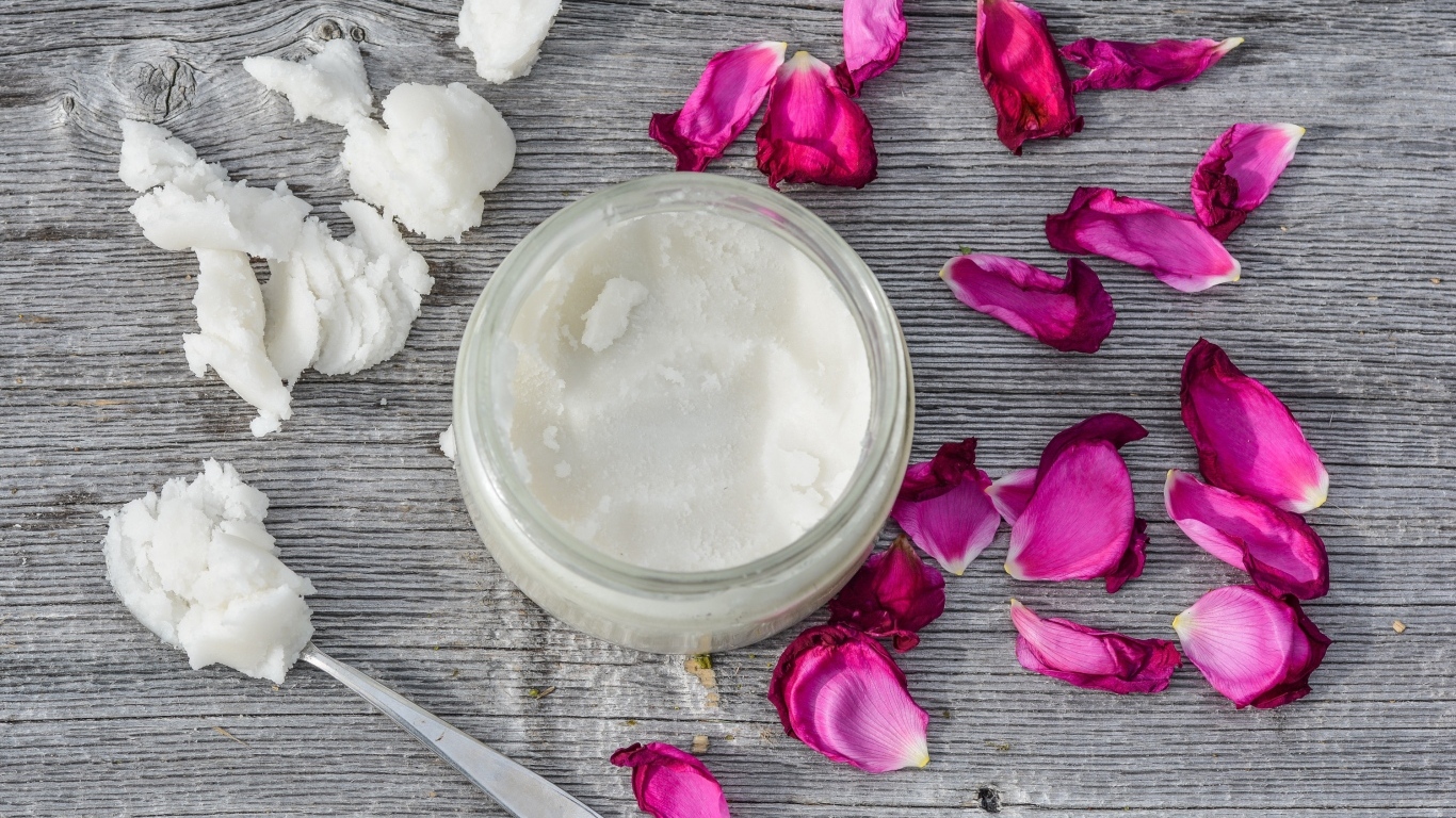 Кокосовое масло с лепестками розы на сером столе