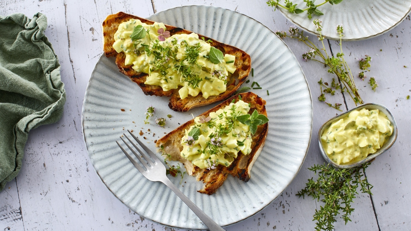 Гренки с кремом и зеленью на тарелке