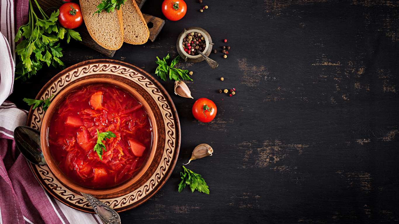 Вкусный красный борщ в тарелке на столе