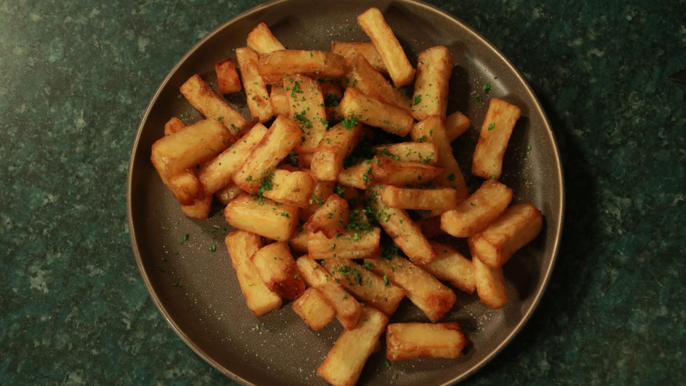 Картофель фри на большой тарелке на столе