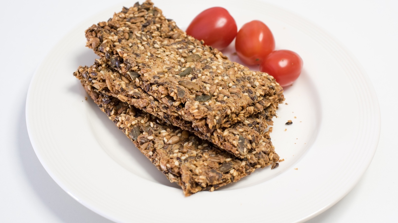 Полезны злаковые хлебцы на тарелке с помидорами