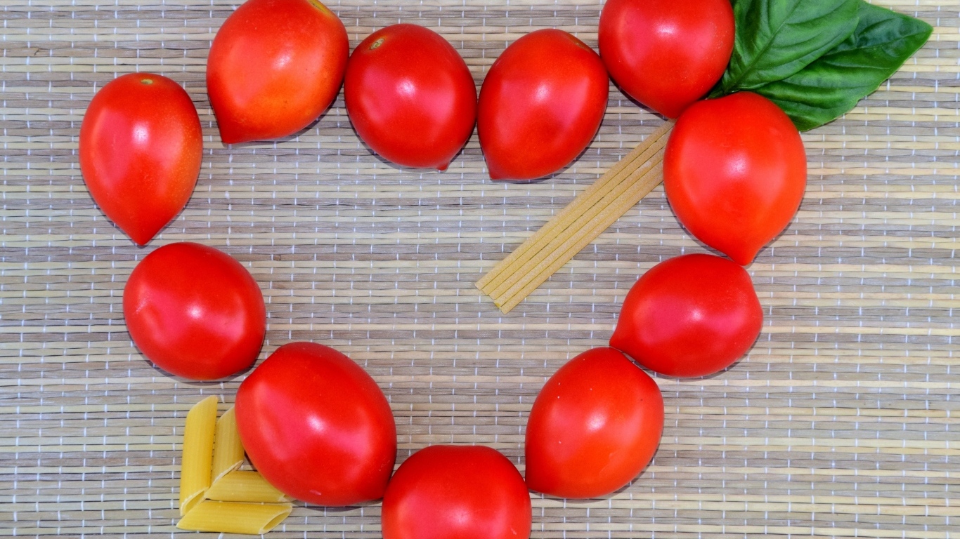 Сердце из помидоров на столе с макаронами