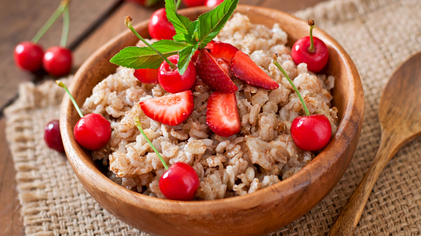 Овсяная каша с ягодами в деревянной миске