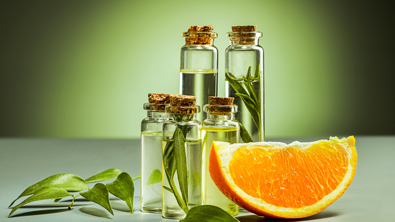 Апельсиновое масло на зеленом фоне с апельсинами