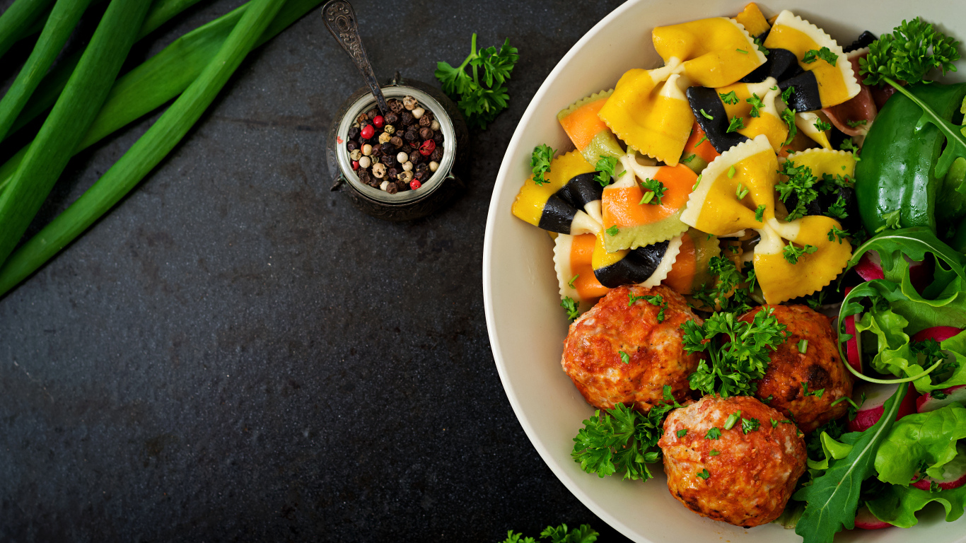 Паста с тефтелями и салатом в тарелке