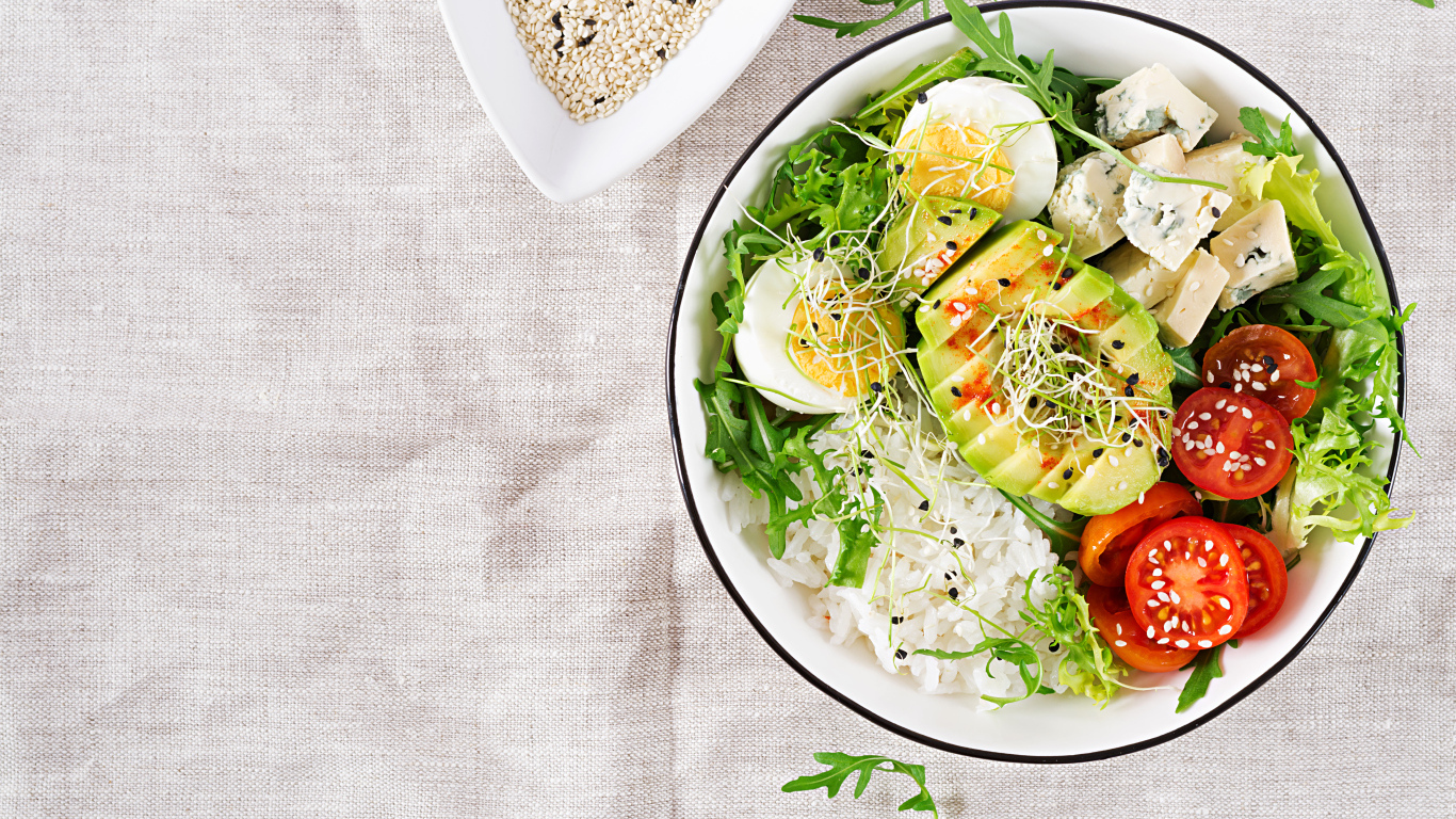 Рис с овощами и авокадо в тарелке