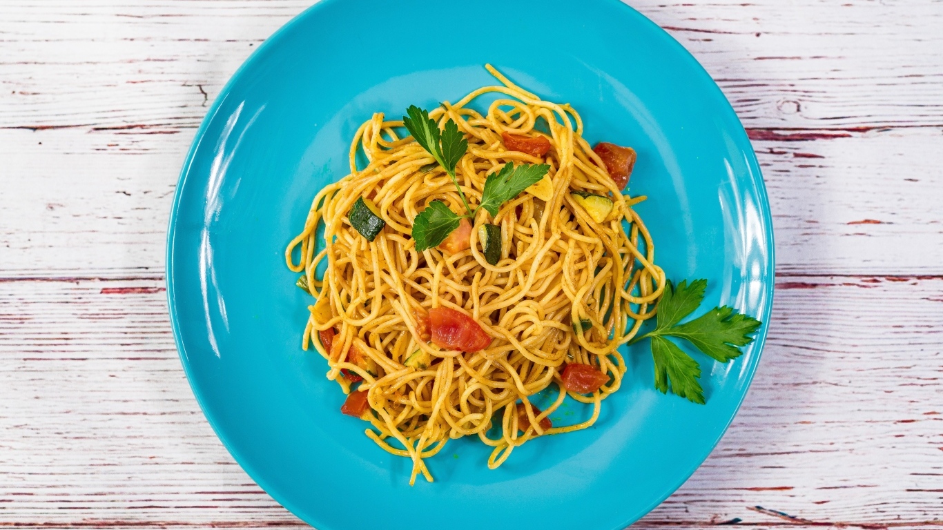 Спагетти с овощами  на голубой тарелке