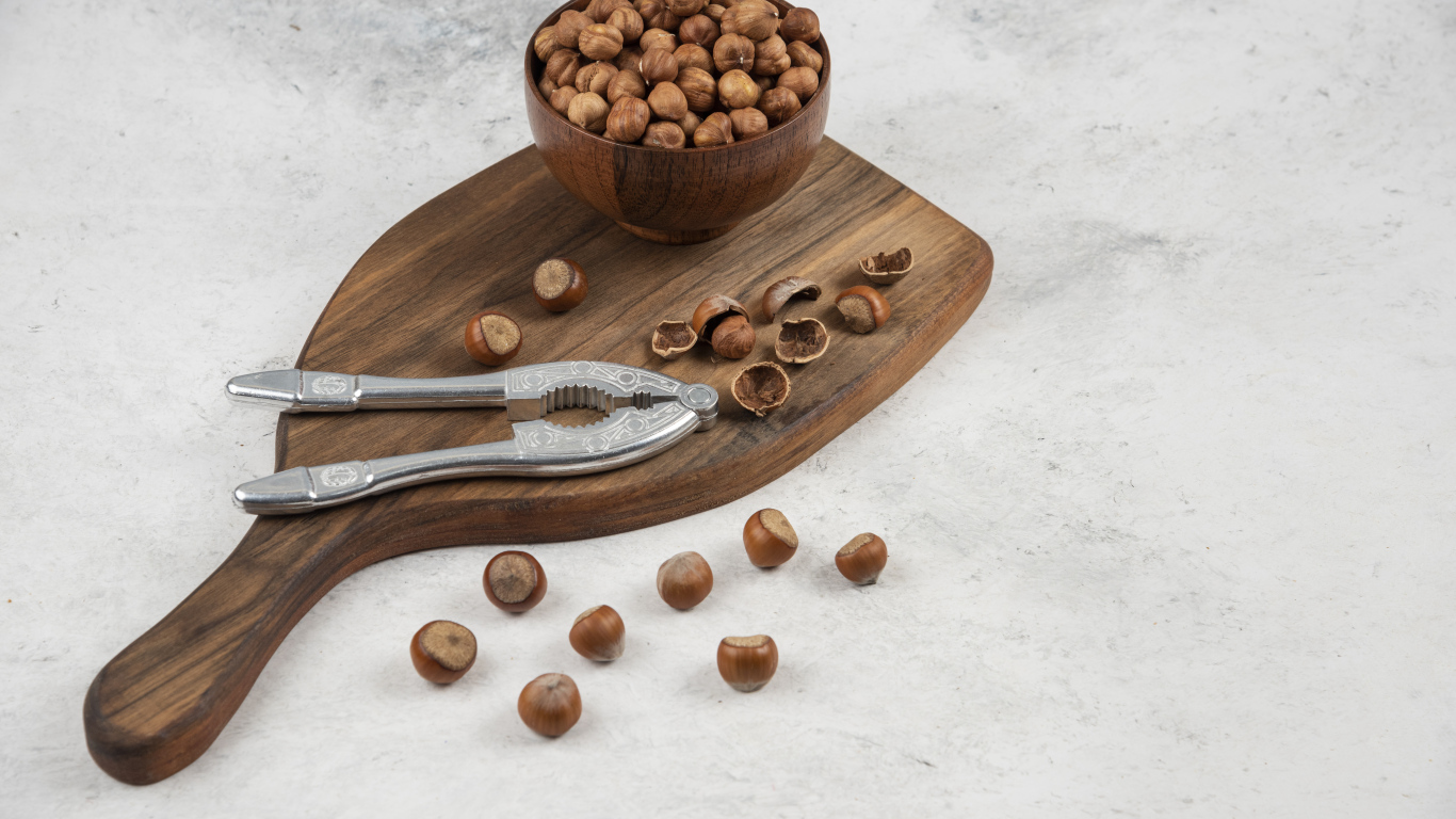 Лесные орехи на сером столе с разделочной доской