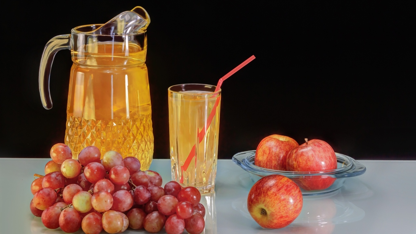 Сок на столе с виноградом и яблоками