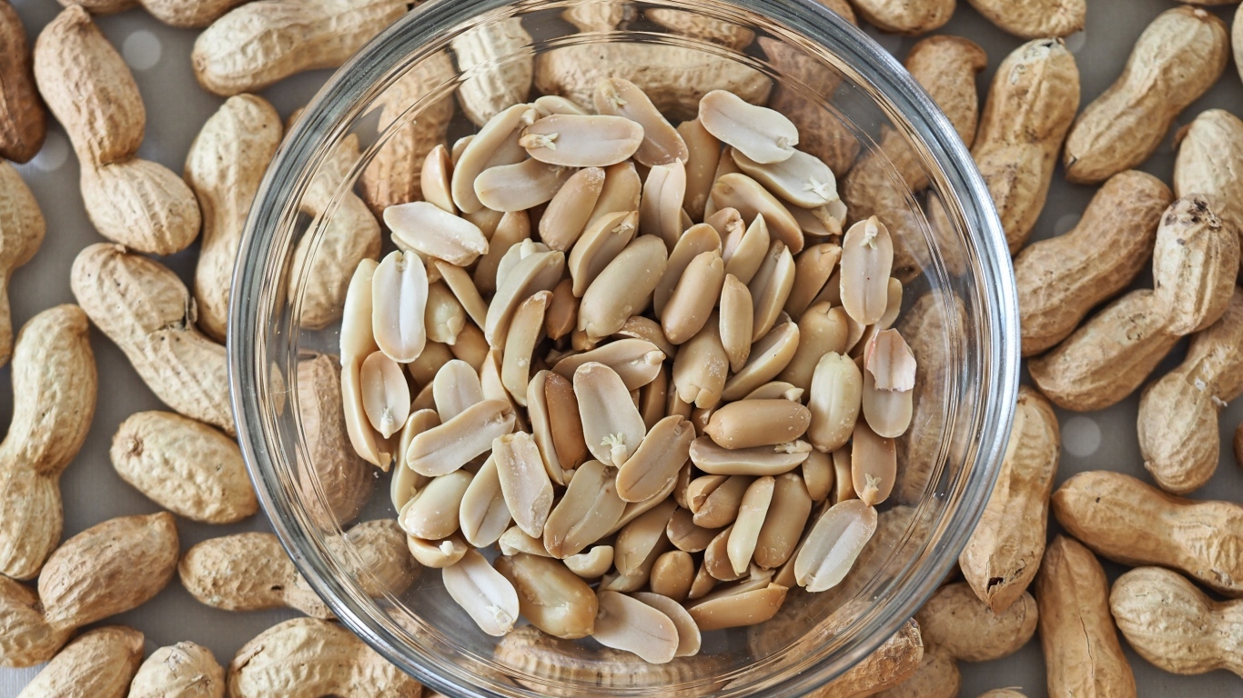 Арахис в стеклянной тарелке на столе 