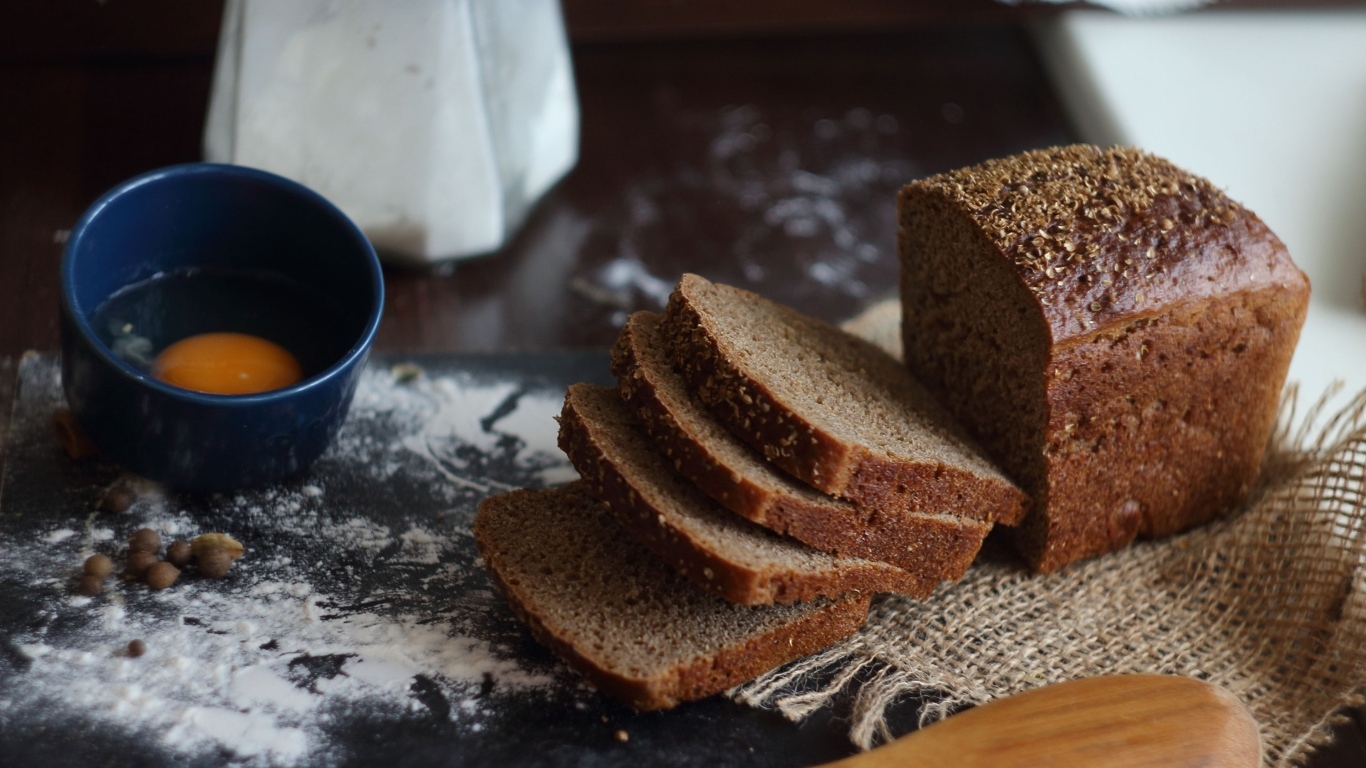 Черный хлеб на столе с мукой