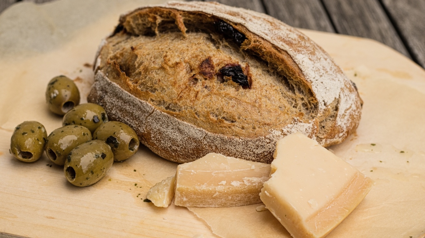 Буханка хлеба с сыром и оливками