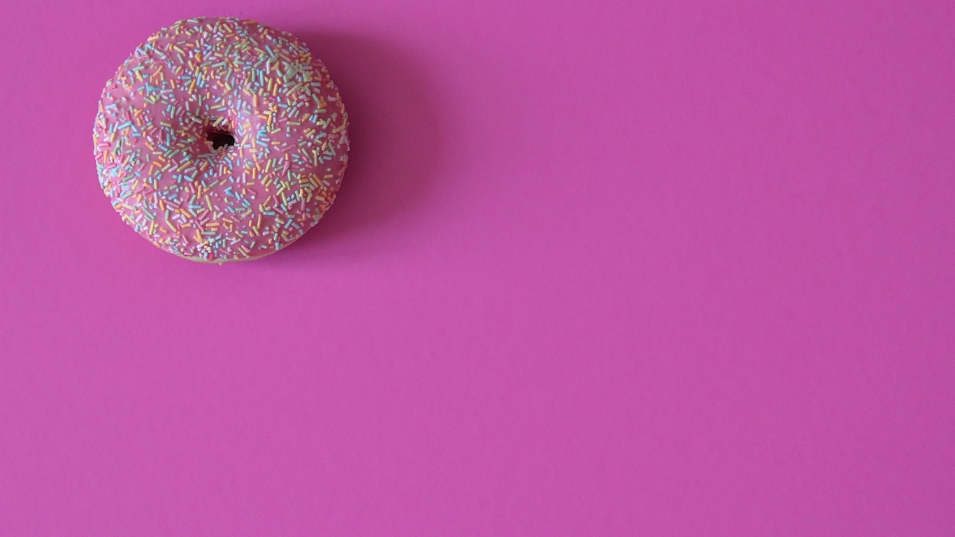 Аппетитный донат с глазурью на розовом фоне