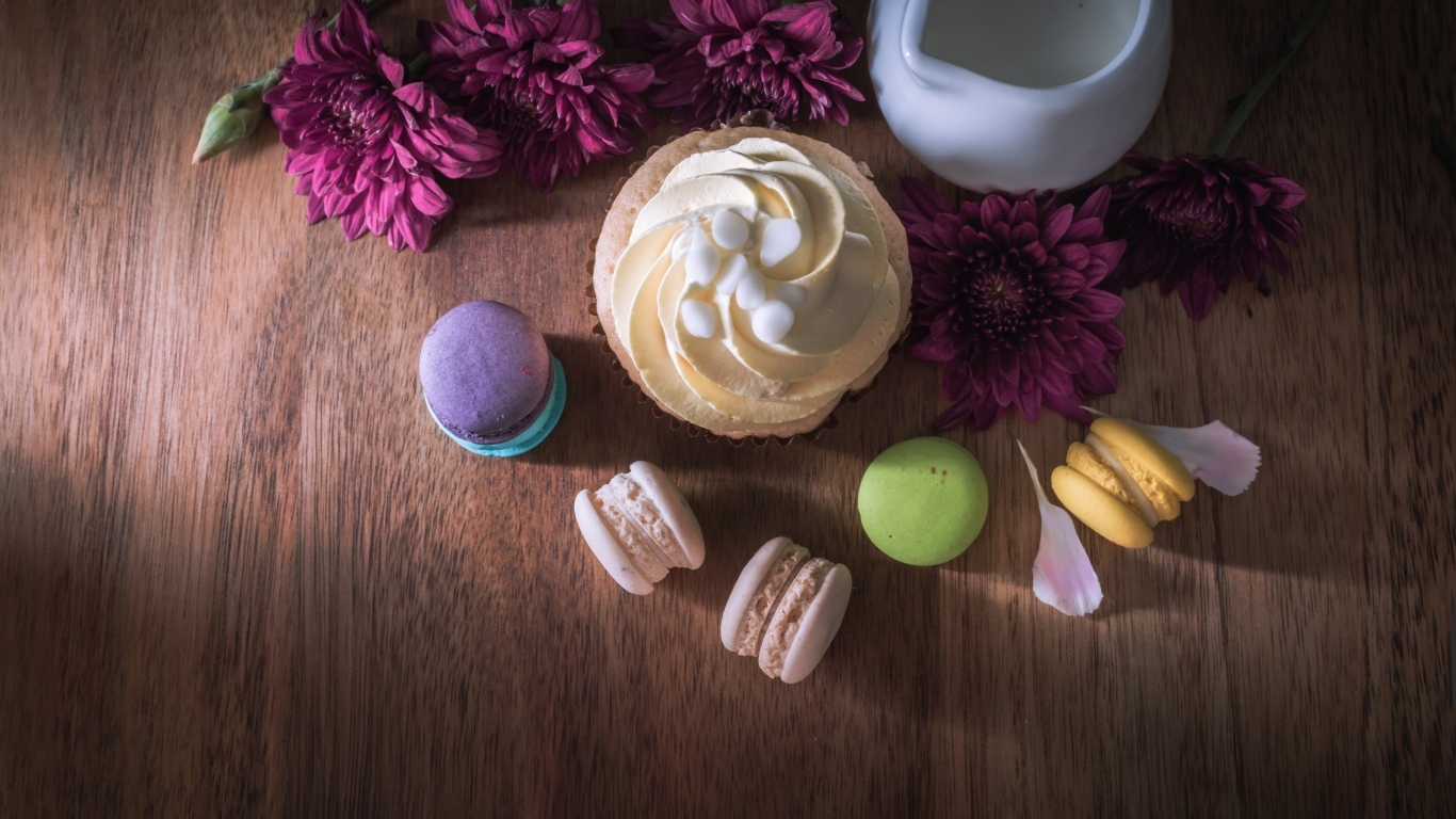 Аппетитные сладкие пирожные с цветами хризантемы на столе