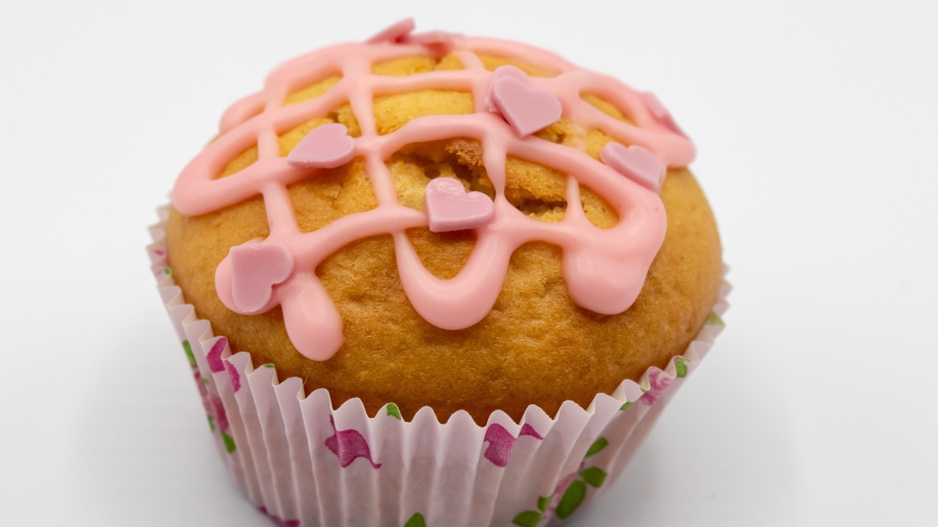 Кекс с клубничной глазурью на сером фоне