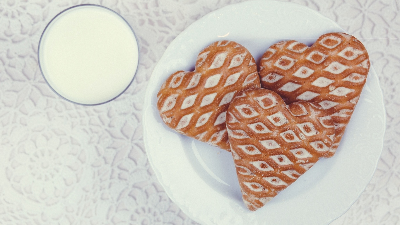 Печенье в форме сердца на столе с молоком