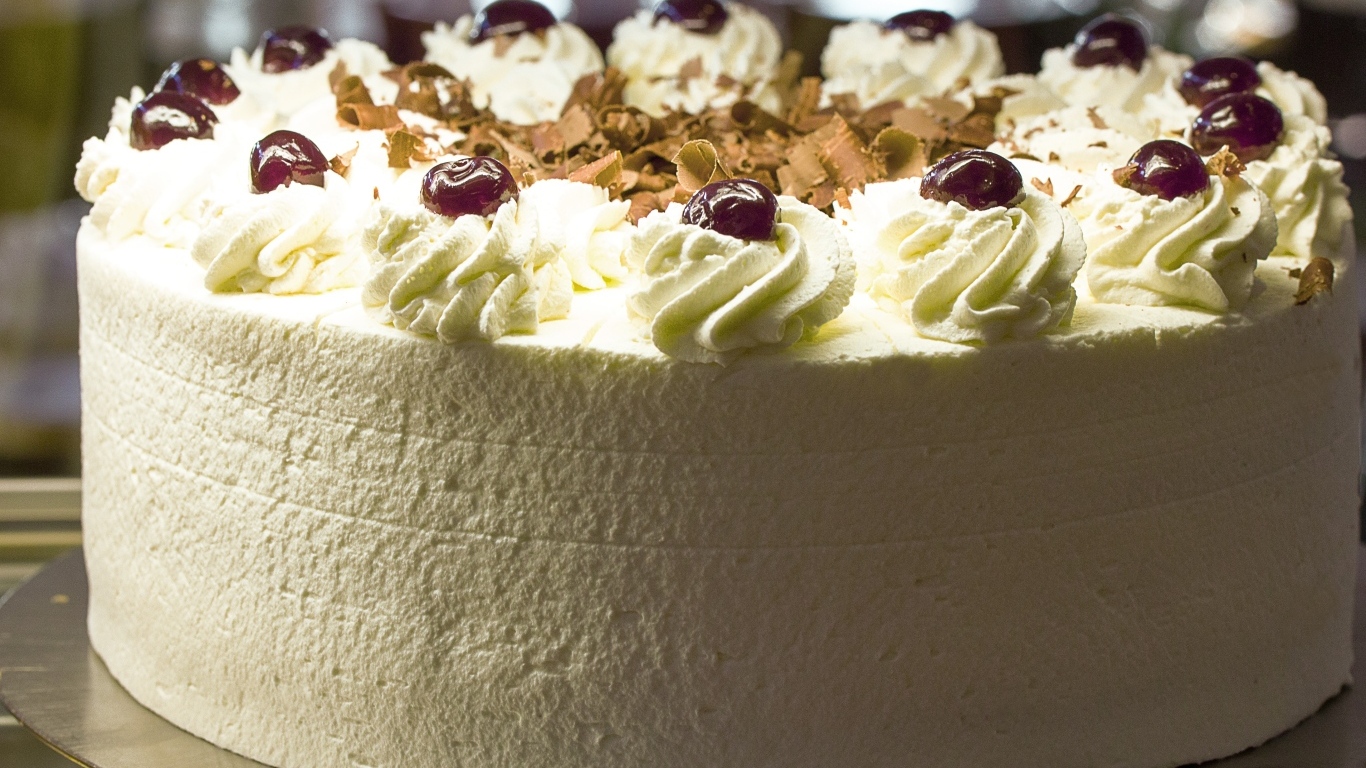 Большой белый торт с ягодами вишни