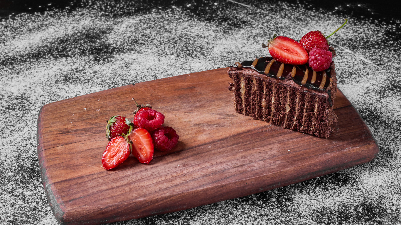 Кусок торта брауни с ягодами на доске