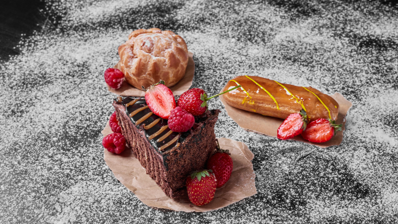 Кусок торта с ягодами на столе с эклером