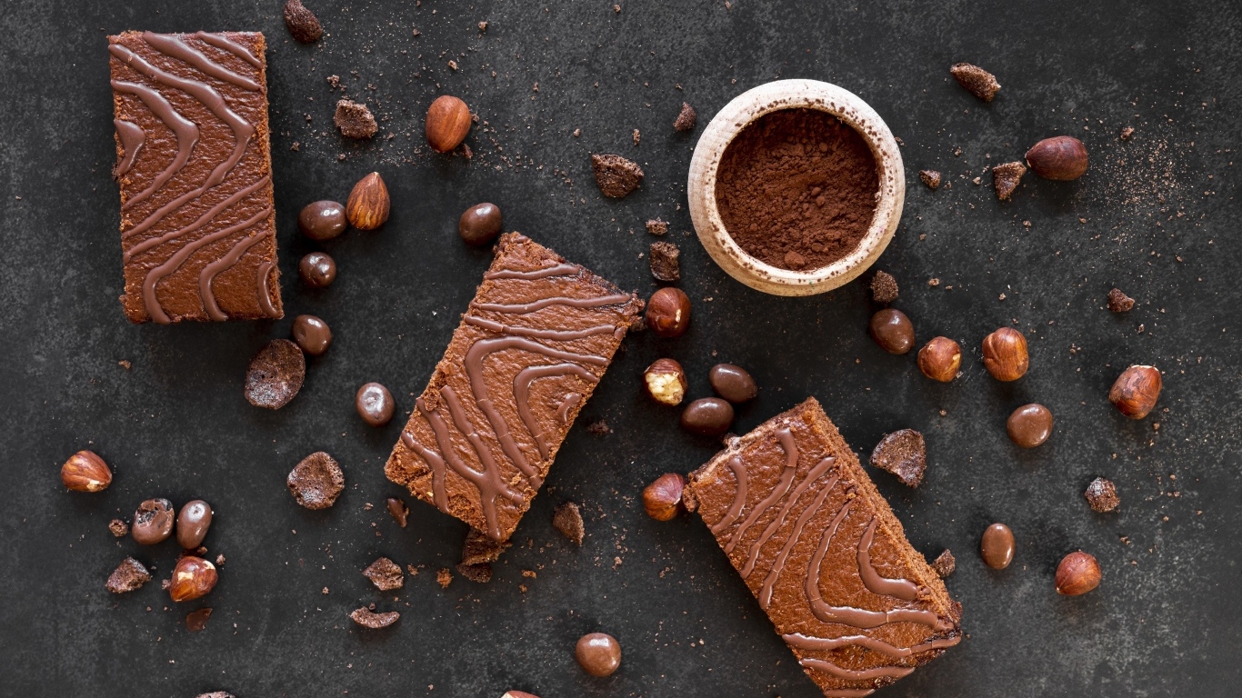 Кусочки пирожных на сером столе с шоколадными зернами