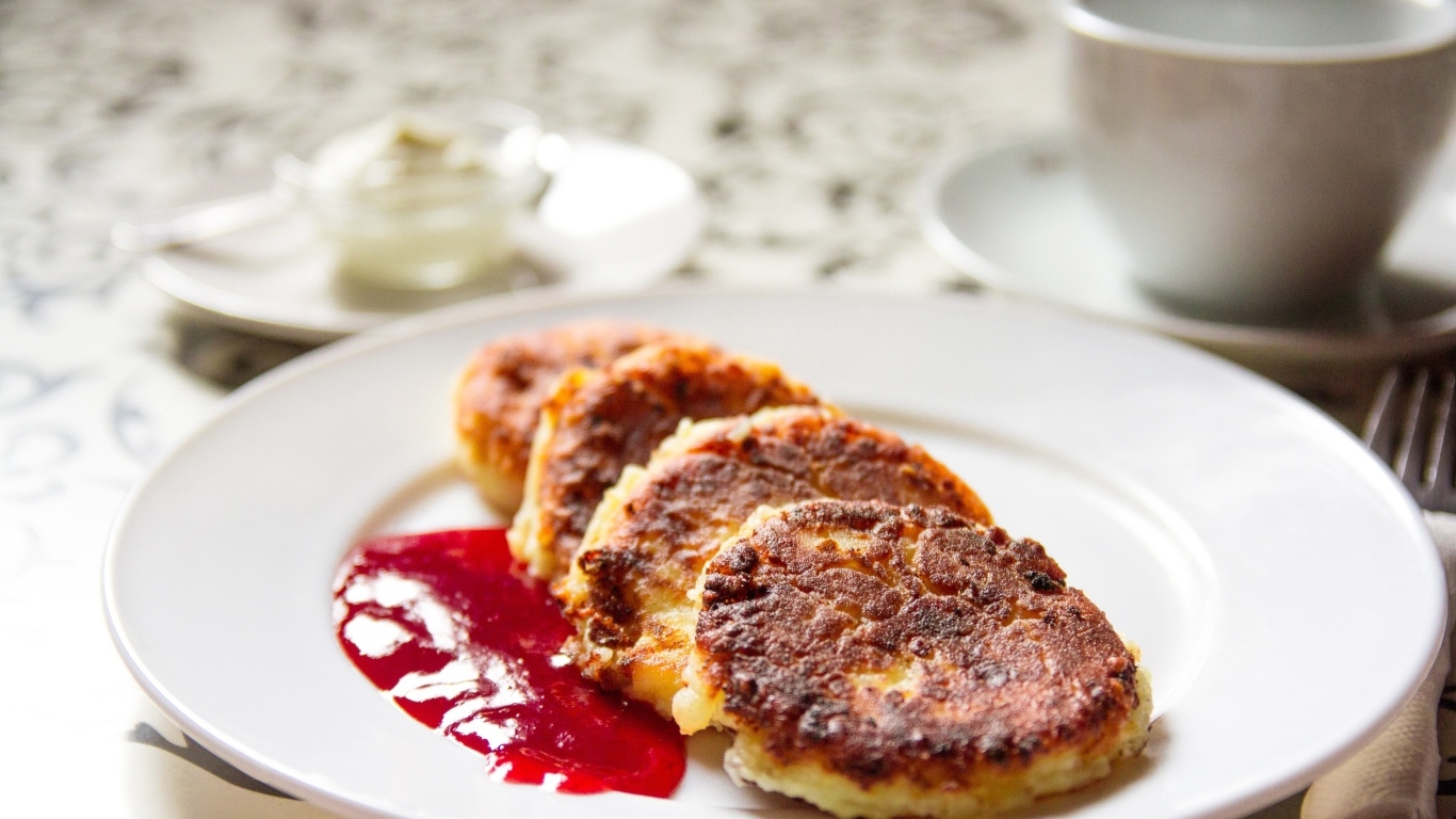 Румяные сырники на тарелке с джемом на завтрак