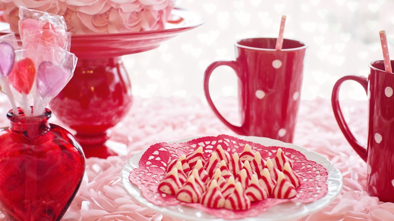 Сладкие розовые конфеты на столе с чаем и тортом