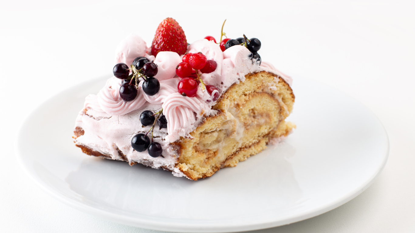 Ломтик сладкого рулета с ягодами и кремом