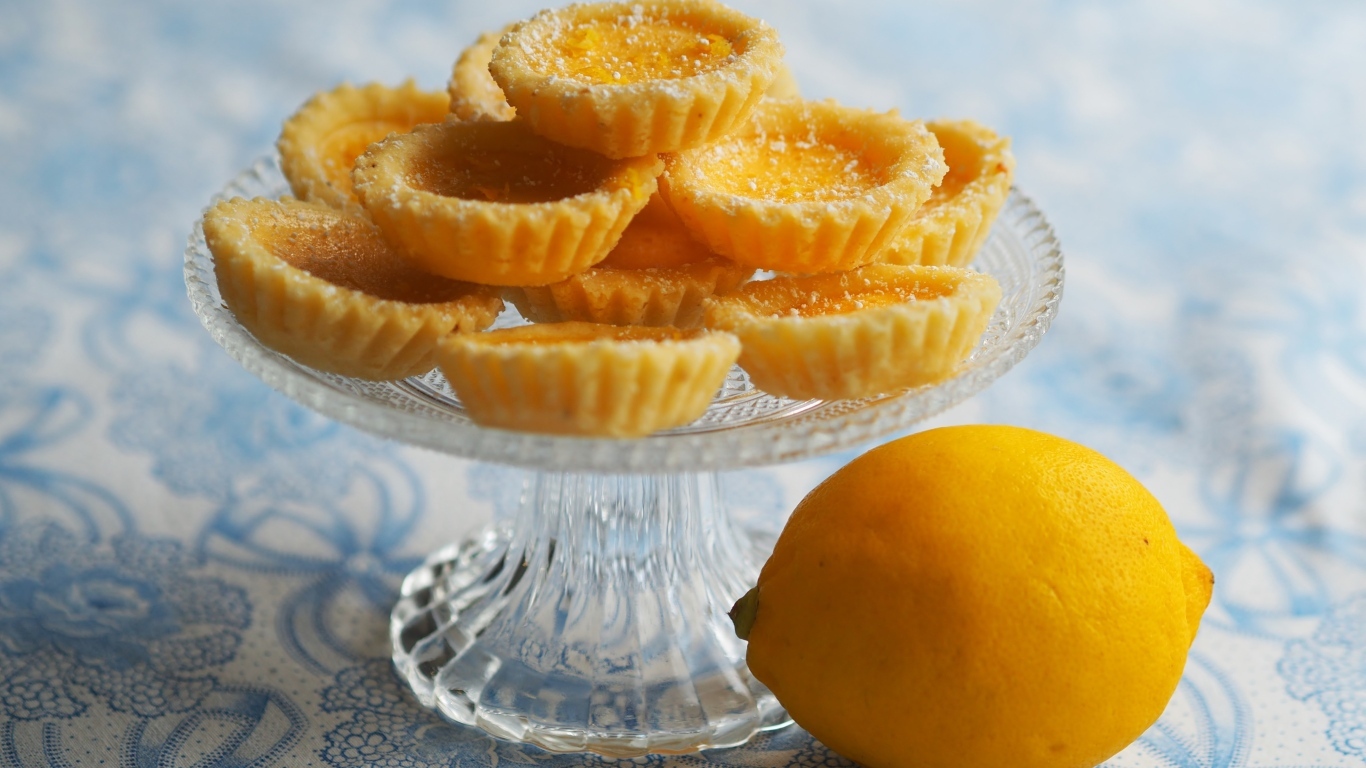 Сладкие песочные корзиночки на столе с лимоном