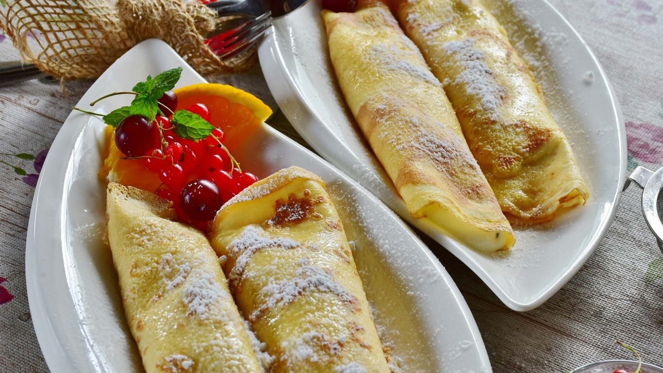 Thin pancakes with berries on the table