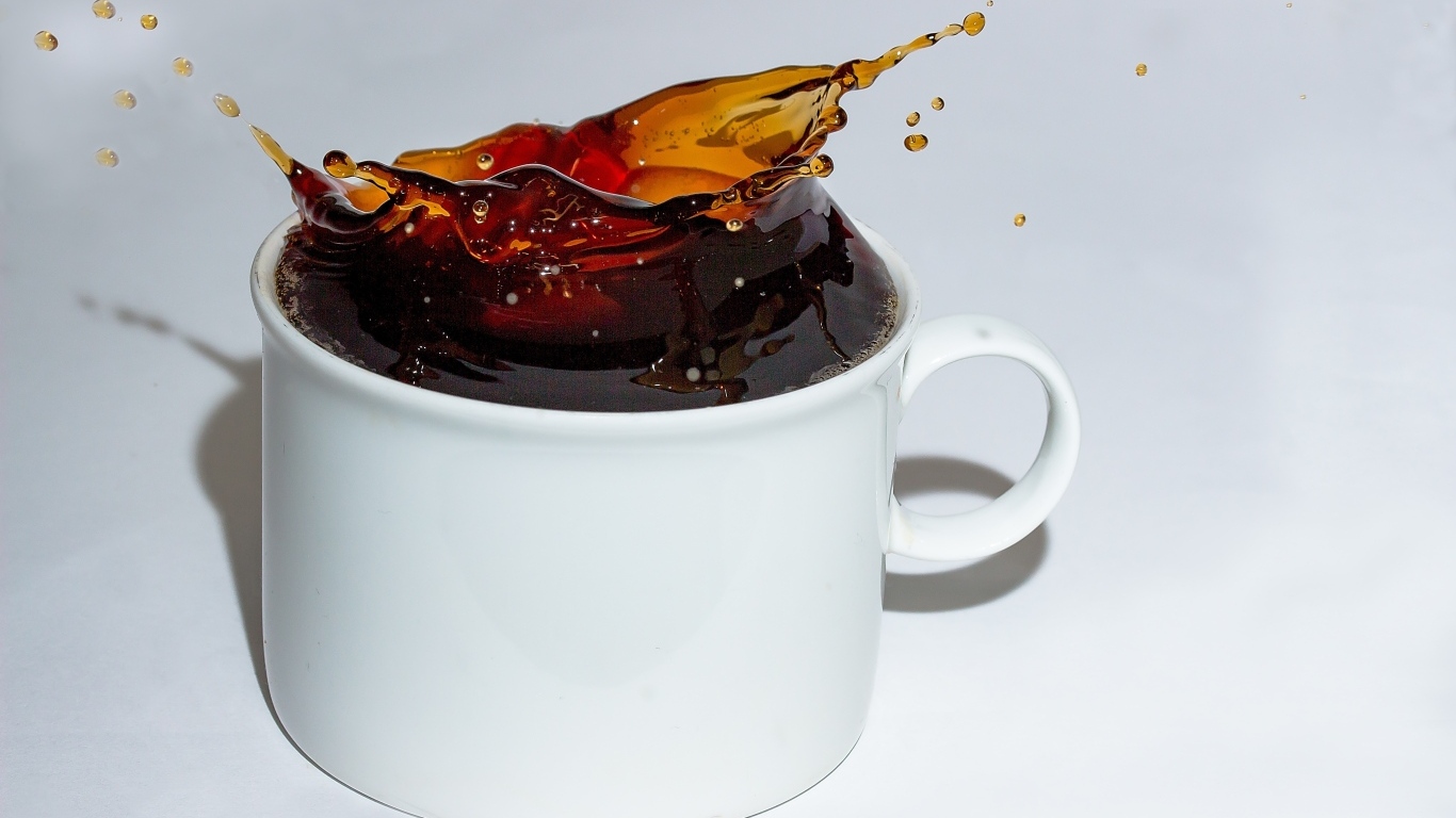 Чашка кофе с брызгами на сером столе