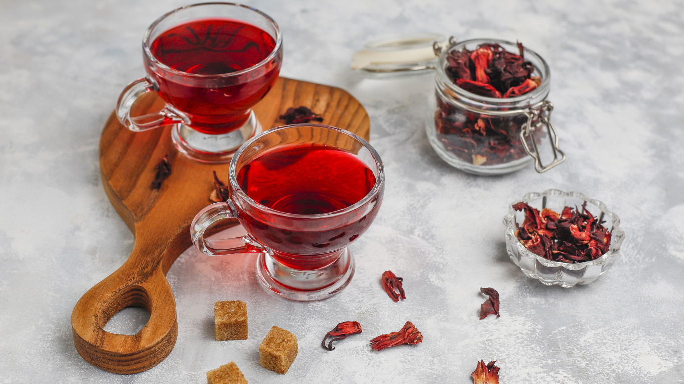 Две чашки чая каркаде на столе с заваркой 