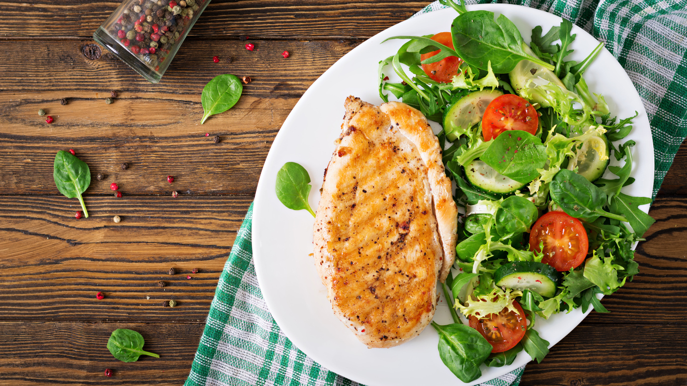 Жареная куриная грудка на тарелке с салатом