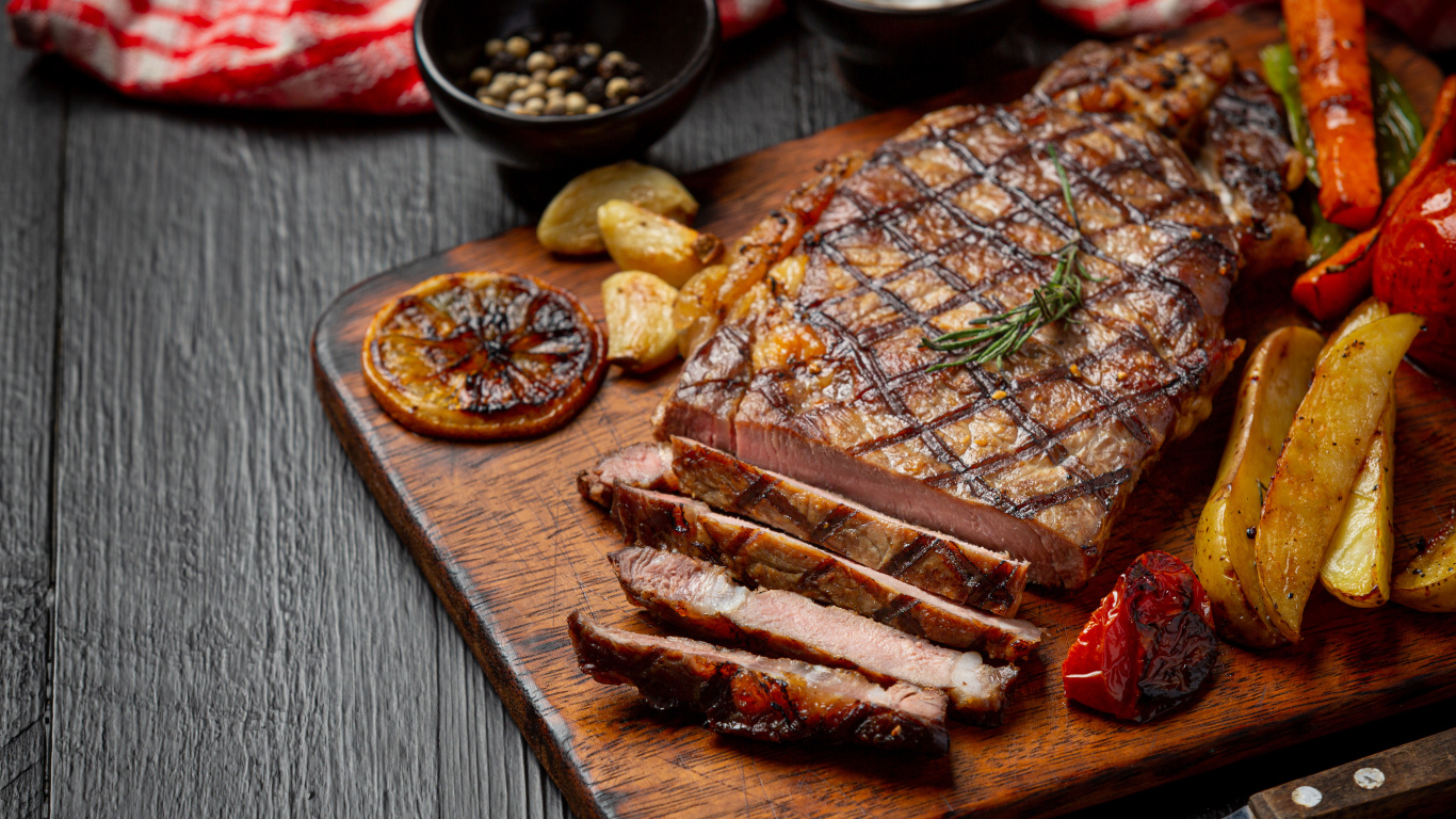 Кусок мясо барбекю на доске с овощами